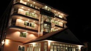 A multi-story hotel with balconies and large windows.