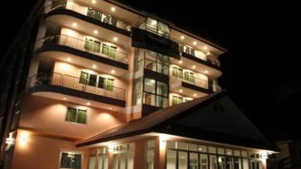 Un hotel de varios pisos con balcones y ventanas amplias.