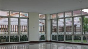 Una habitación espaciosa con ventanas amplias y suelo pulido.