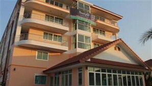 Un hotel de varios pisos con balcones, ventanas amplias y un cartel que indica que es un hotel.