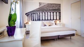 Un dormitorio moderno con una cama grande, una mesita de noche, una silla y una planta en maceta.