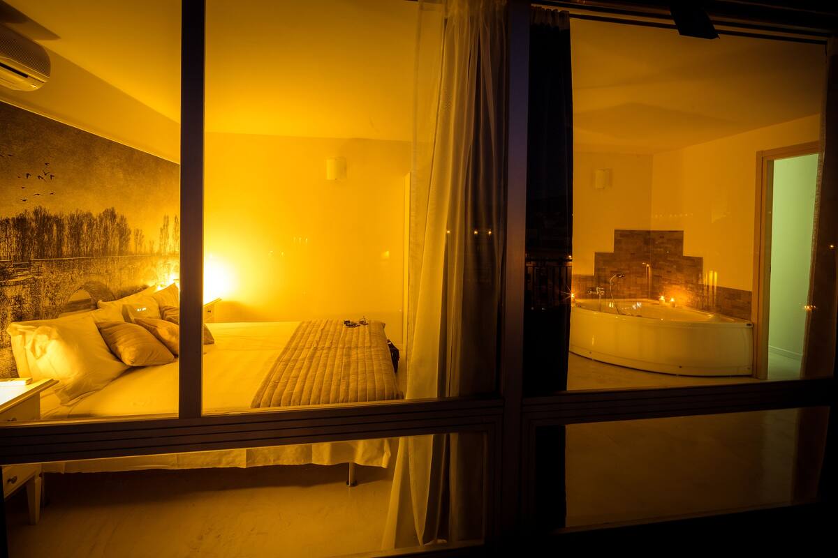 Una habitación de hotel con cama, escritorio y vista a un jacuzzi.