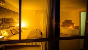 Een hotelkamer met een bed, een bureau en uitzicht op een jacuzzi.