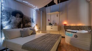 Une chambre à coucher avec un lit, une table de chevet et une baignoire intégrée.