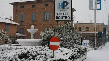 Ein Hotel namens "HOTEL ROUTE 9" mit einem Schild, auf dem "HOTEL ROUTE 9" und "HOTEL" stehen, an einem Gebäude.