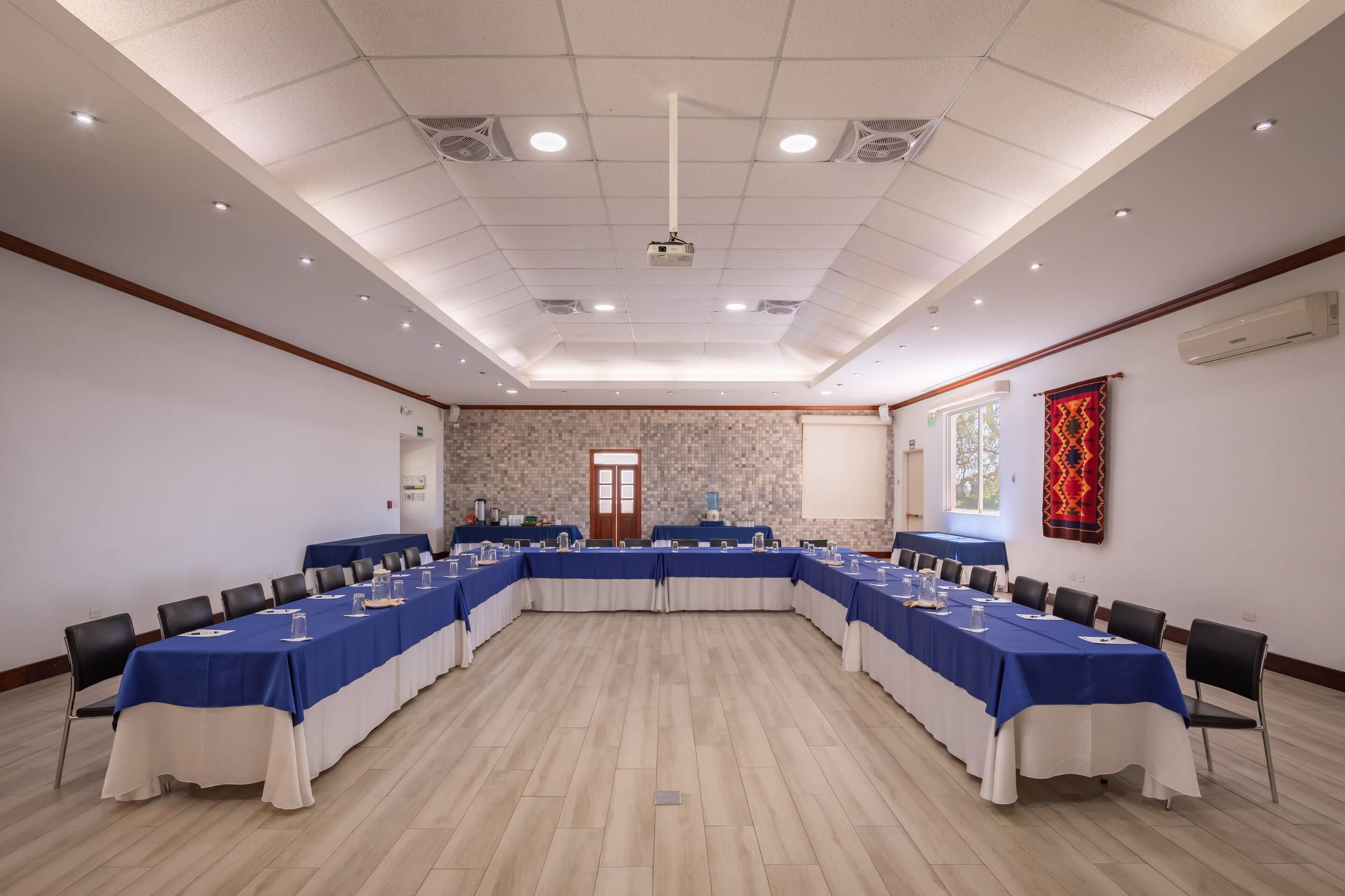 A conference room with a long table, chairs, and a projector.