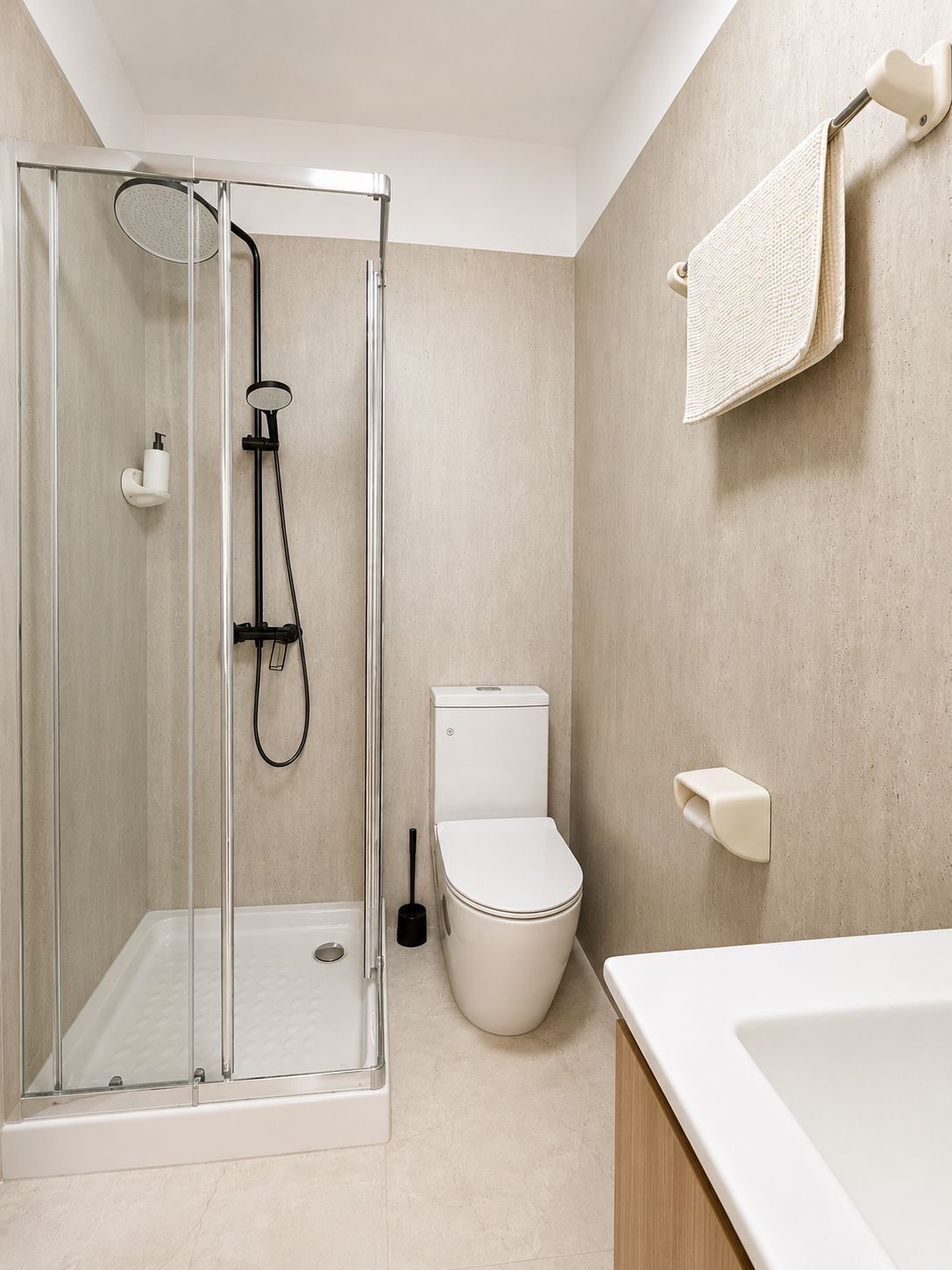 Une salle de bain moderne avec une douche à parois de verre, des toilettes et un lavabo.