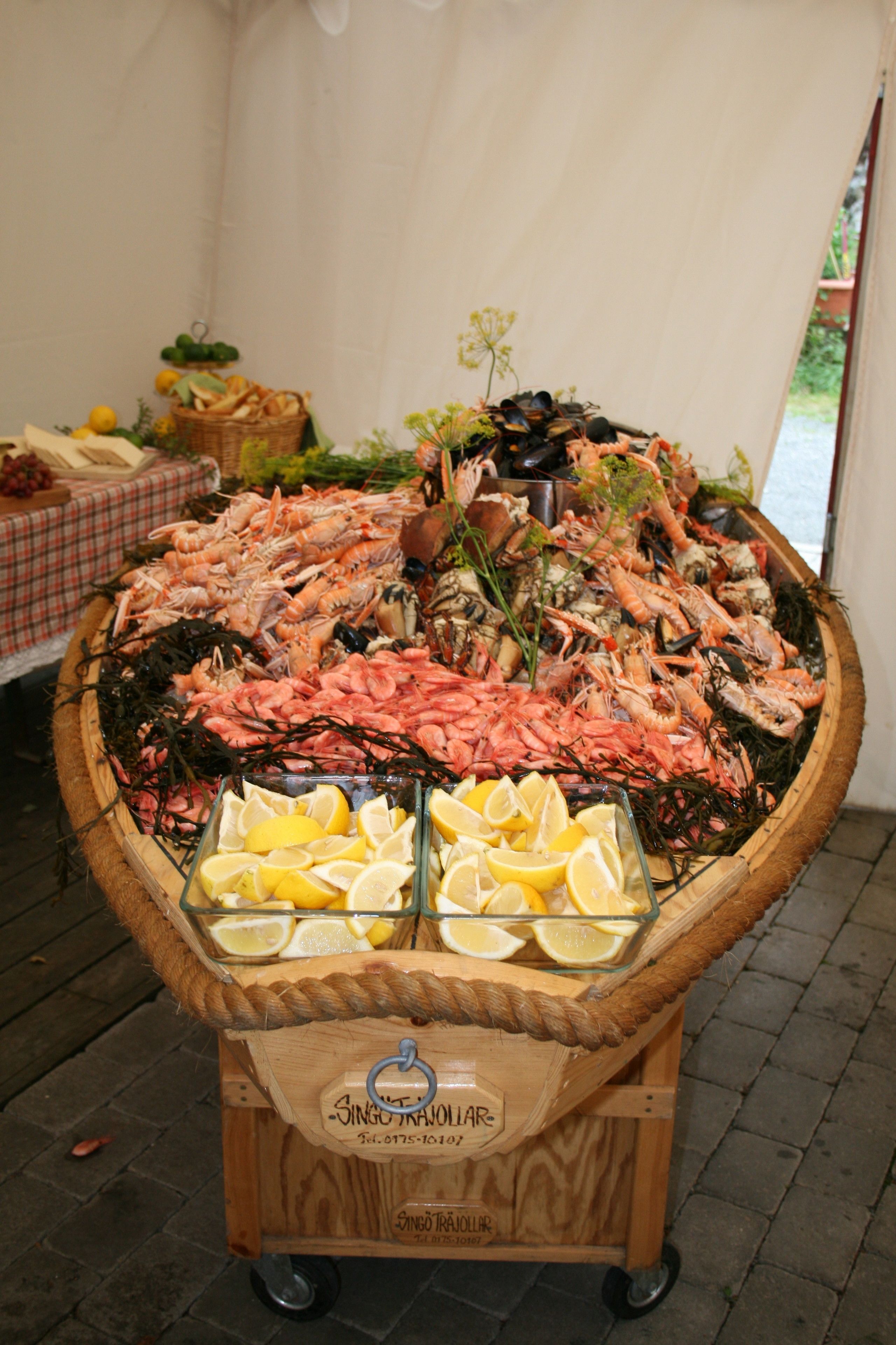 Carrito de mariscos con distintos tipos de productos del mar y rodajas de limón.