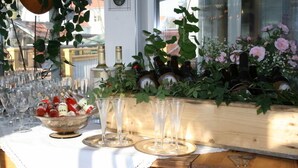 A table set with wine bottles and glasses, surrounded by greenery and flowers. - Brännö Värdshus & Pensionat Baggen (Branno)