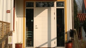 A building with a sign reading "PENSIONAT" and a door with a sign above it. - Brännö Värdshus & Pensionat Baggen (Branno)