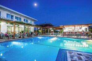 A swimming pool with lounge chairs and a bar area. - Belvita (Rhodes)