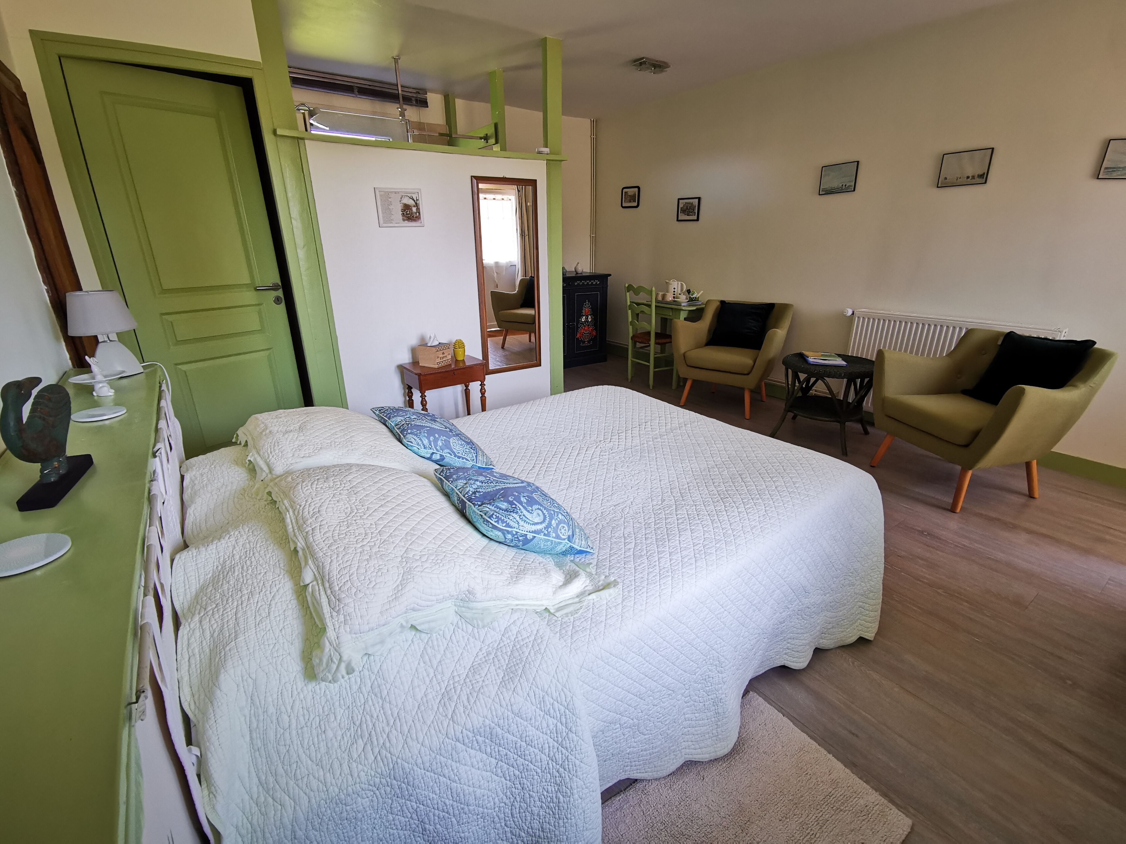 Une chambre à coucher avec un lit, une chaise, un bureau et un radiateur.