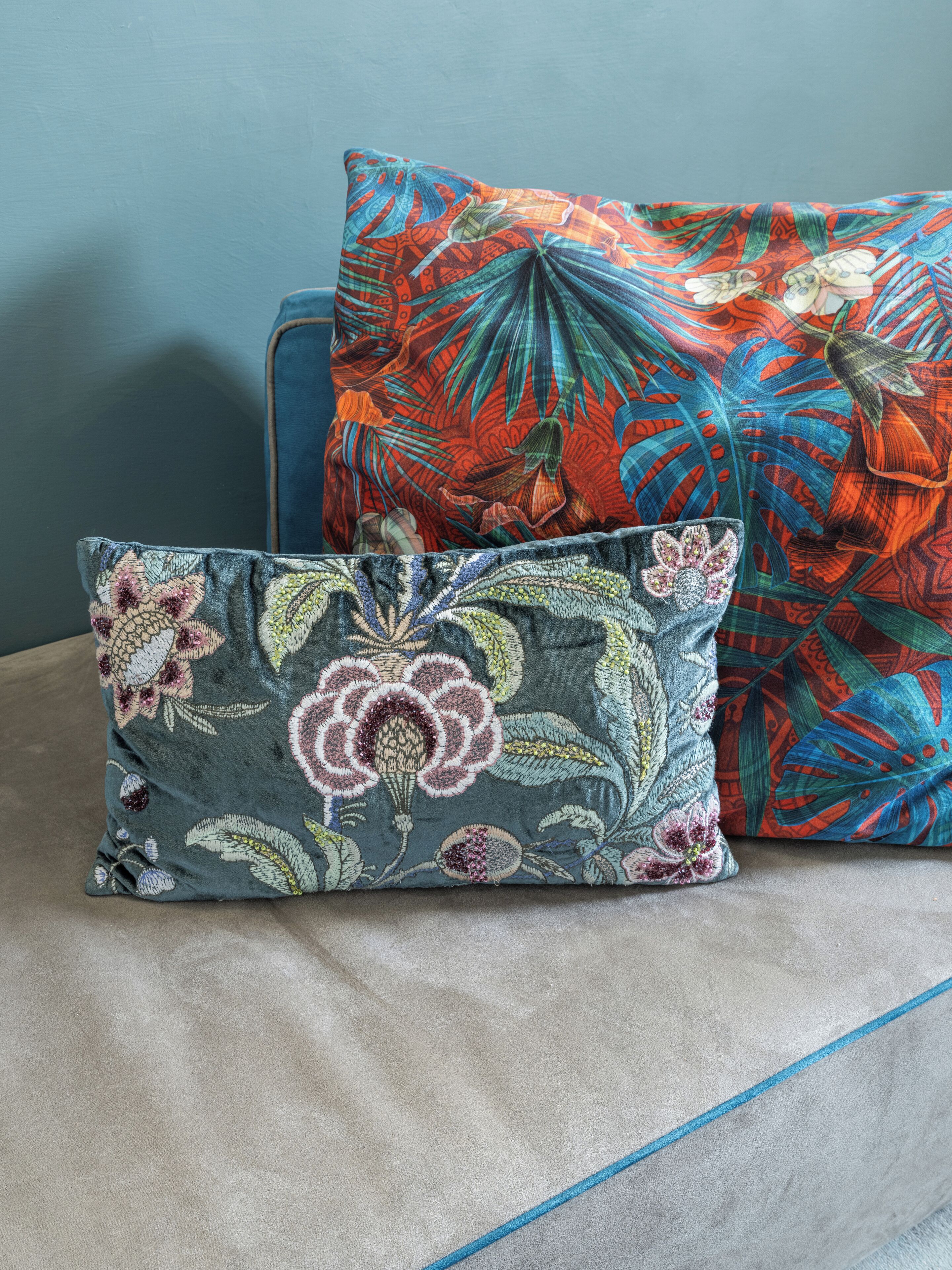 Dos almohadas con diseños florales sobre una tela texturizada.