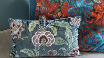 Dos almohadas con diseños florales sobre una tela texturizada.