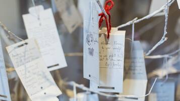 A display of handwritten notes attached to strings, likely for decoration or information purposes.