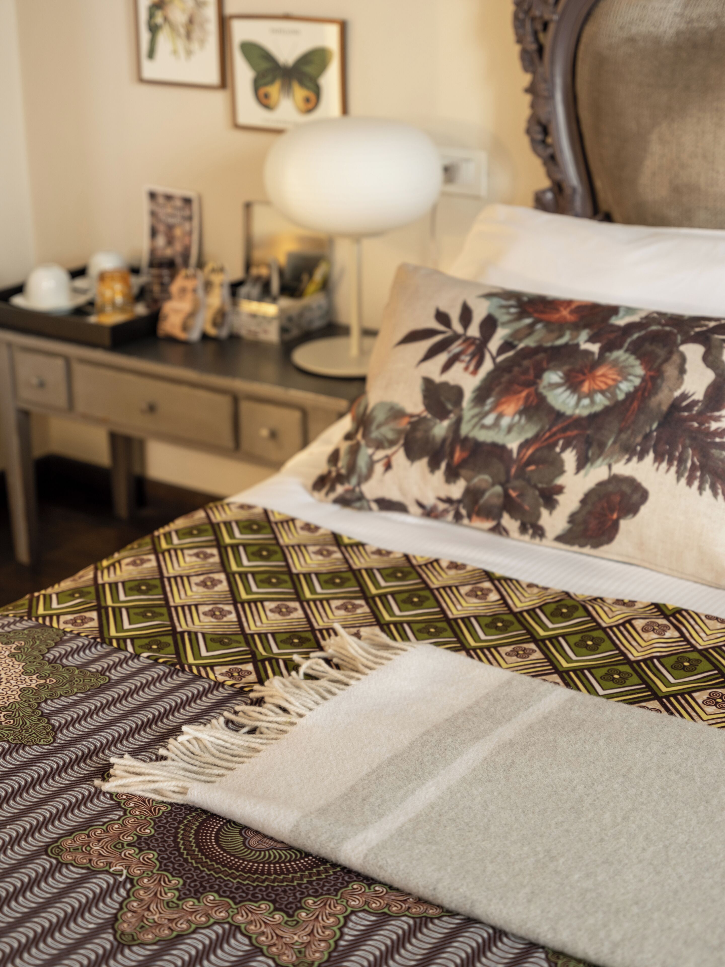 A neatly arranged bedroom with a bed, a desk, and a lamp.