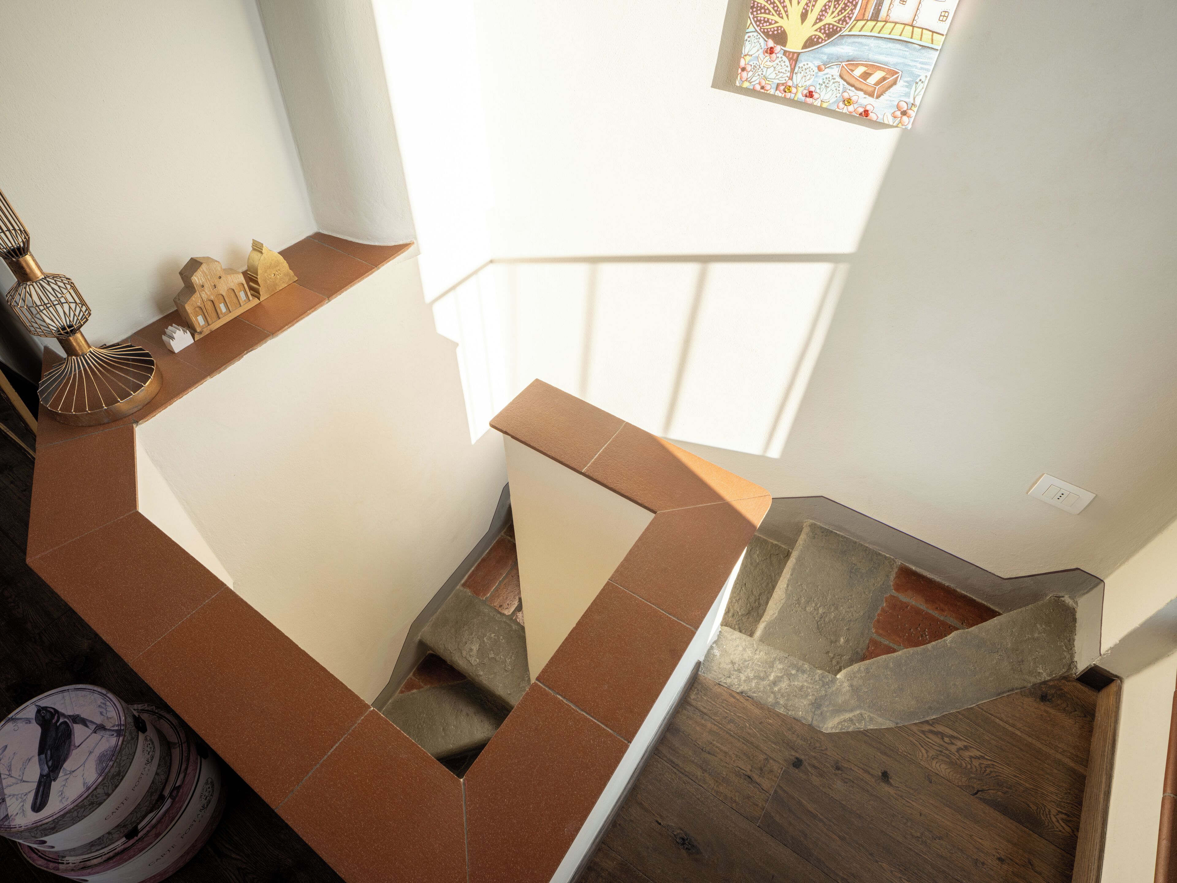 Een trap met een houten vloer en een landingsplaats met bruine tegels.