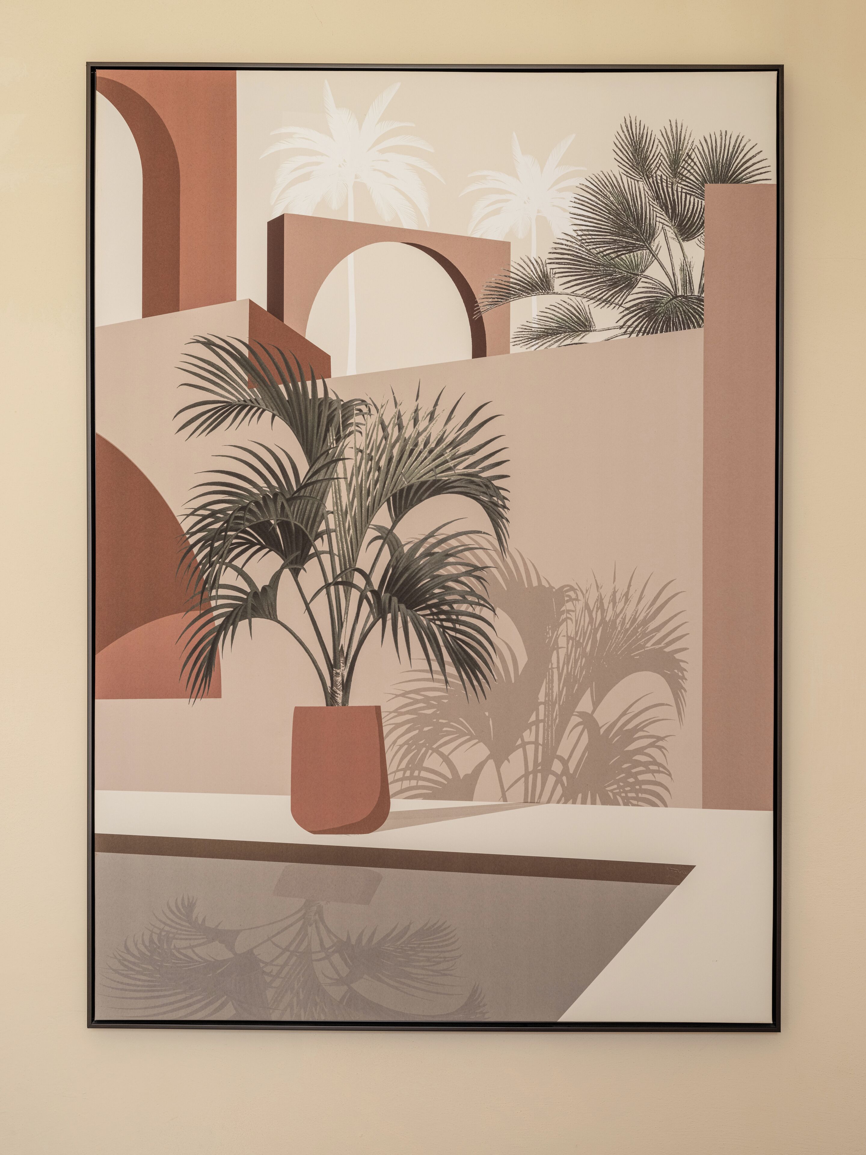 A framed artwork depicting a potted plant with palm fronds in a geometric setting.