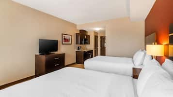 Habitación de hotel con dos camas, televisión, escritorio y baño.