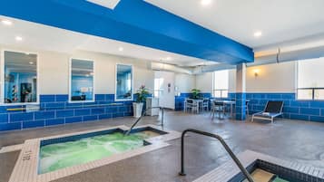 Una piscina techada, sillones reclinables de piscina
