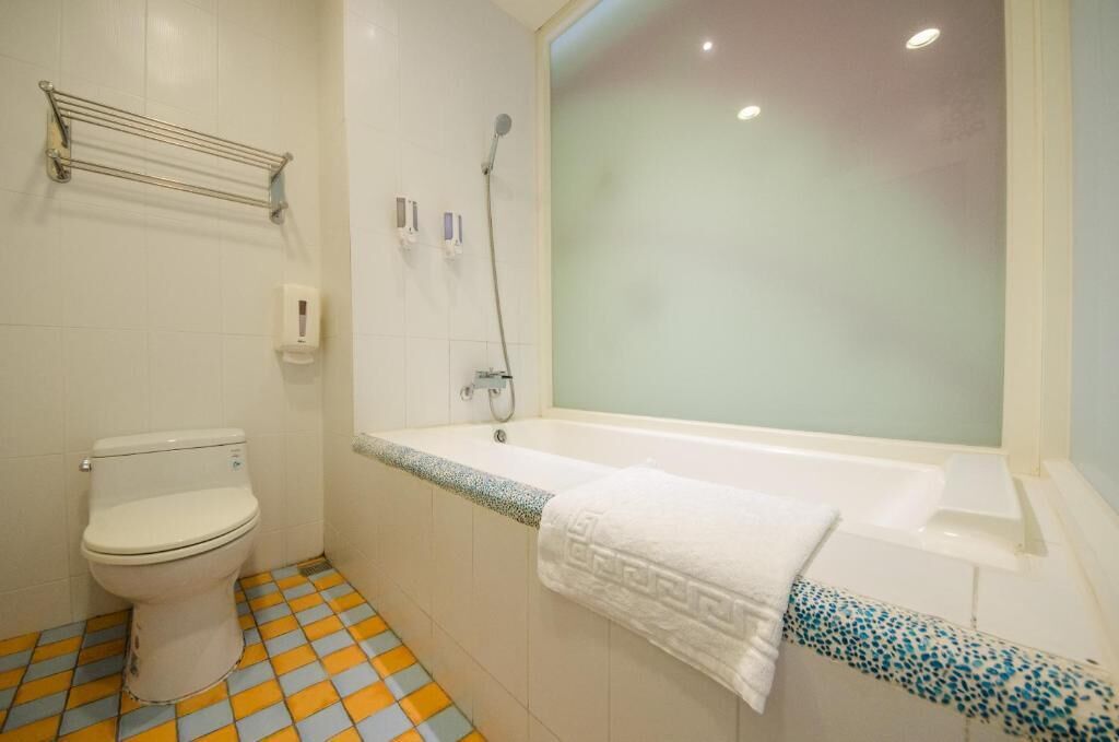 A bathroom with a toilet, a bathtub, and a shower.