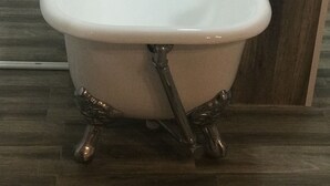 A white freestanding bathtub with a modern faucet and a wooden sideboard. - Hotel Funnytime (Bucharest)