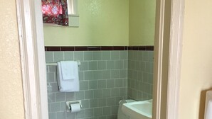 A small bathroom with a toilet, sink, and tiled floor. - Shaws Komfort Motel (Savannah)
