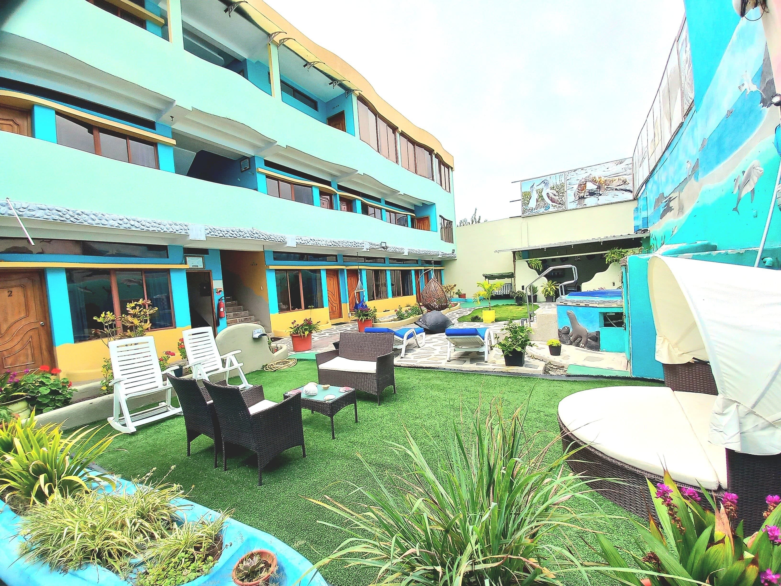 A courtyard with outdoor seating, artificial grass, and potted plants.