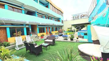 A courtyard with outdoor seating, artificial grass, and potted plants.