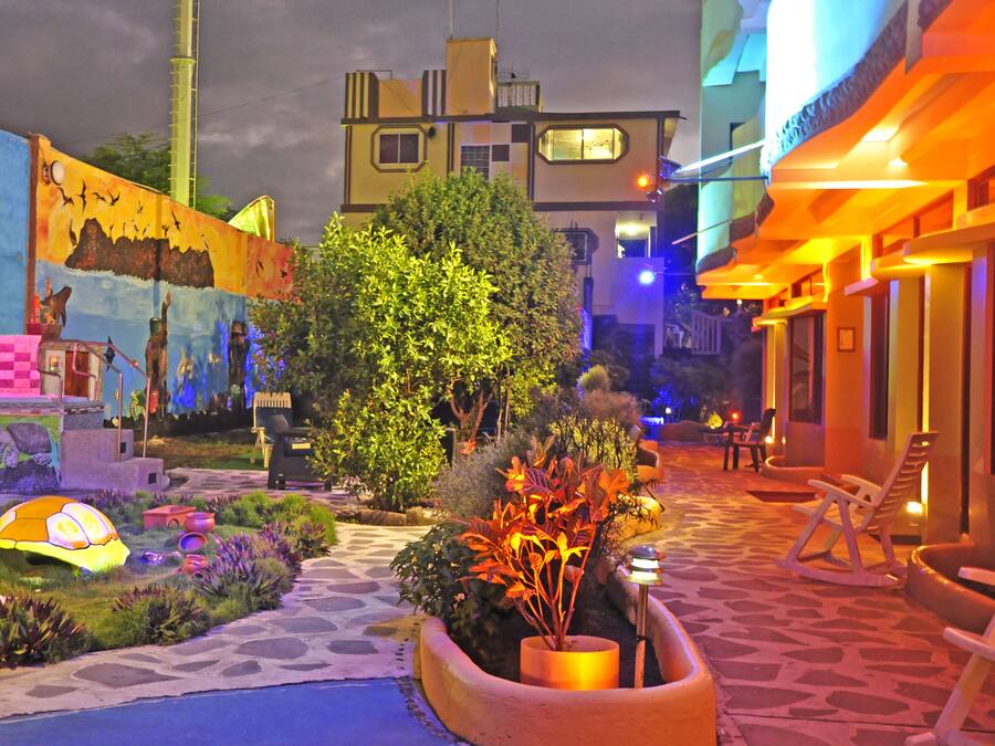 A courtyard with a pathway, potted plants, and outdoor seating.