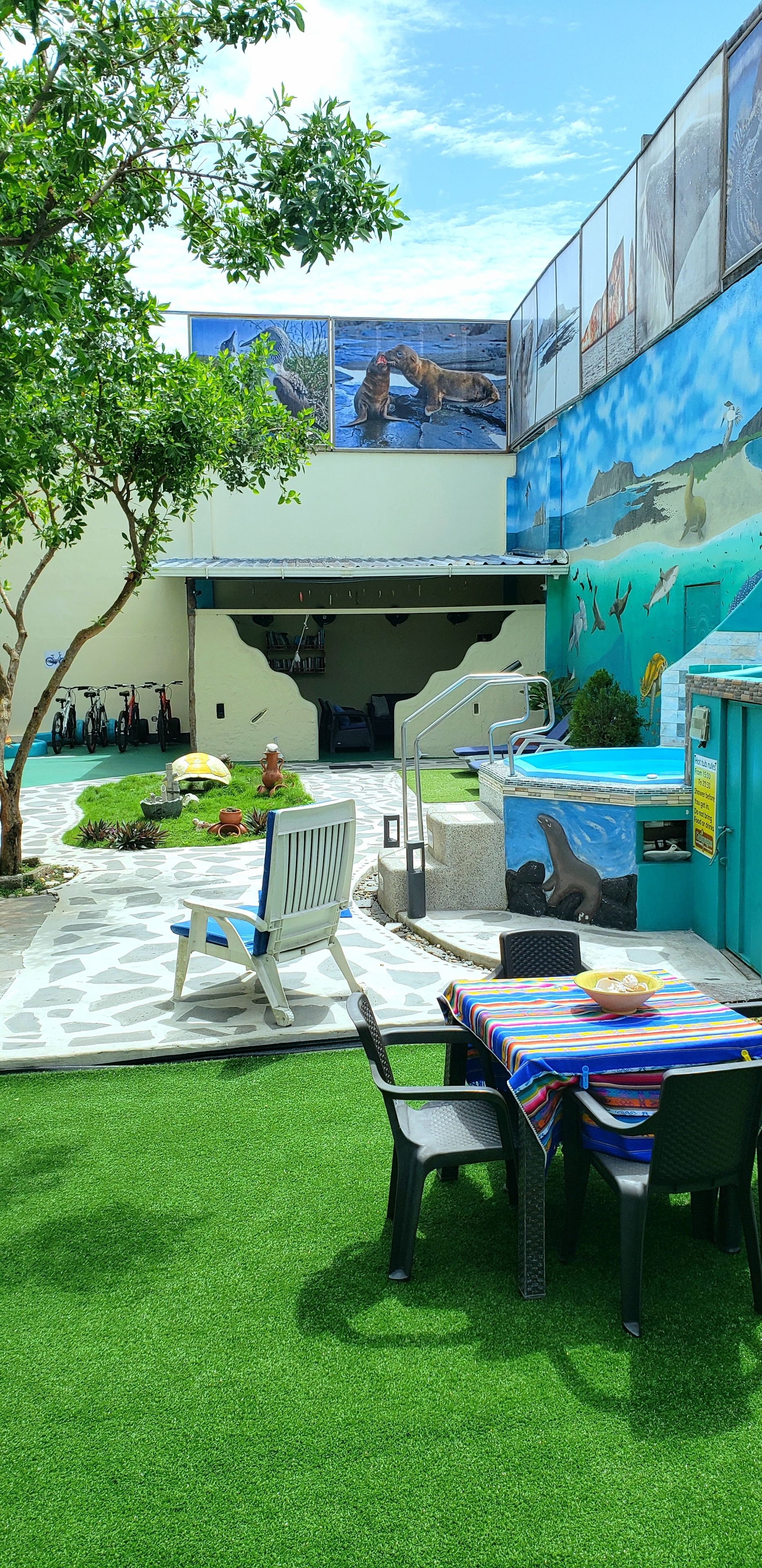 A patio area with a pool table, chairs, and a mural of marine life.