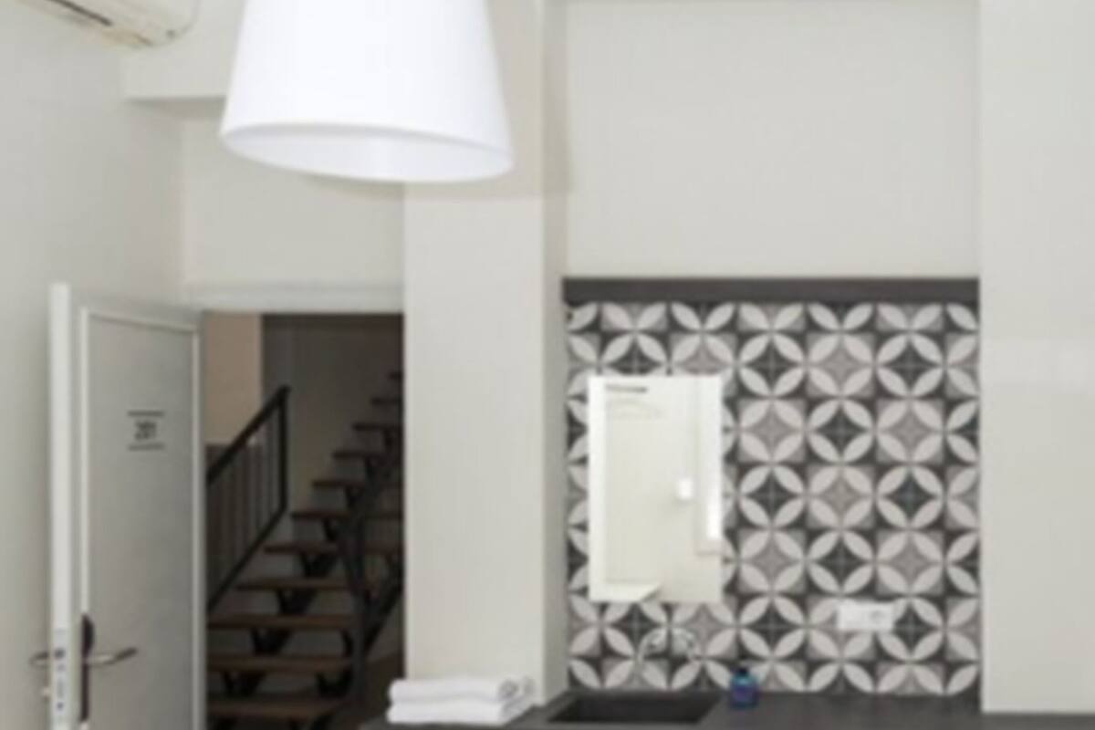 Un baño moderno con lavamanos, espejo y pared con diseño.