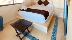A bedroom with a bed, a ceiling fan, a window, and a small table. - La Constanza de Rulo (Holbox)