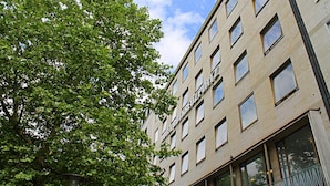 A multi-story hotel building with a modern architectural design, featuring a series of windows and balconies. - Hotel Rotkreuzplatz (Munich)