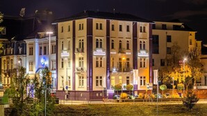 A hotel with multiple floors, balconies, and a sign indicating it is a hotel.