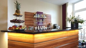 A bar area with a fruit display, shelves of bottles, and a coffee machine.
