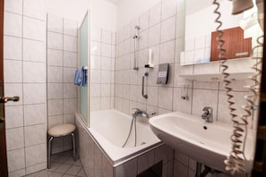 Une salle de bain avec une baignoire, un lavabo et une douche.