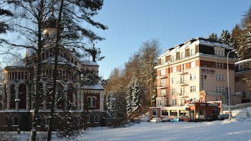 Un hôtel à étages, une enseigne bien visible et une rue recouverte de neige.