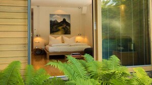 A bedroom with a bed, a painting, and a window with blinds. - Hotel Schindlerhof (Nuremberg)