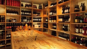 A wine cellar with wooden shelves stocked with various bottles of wine. - Hotel Schindlerhof (Nuremberg)