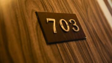 A wooden surface with a black sign displaying the number 703.