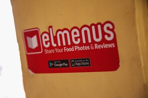 A red and white logo for 'elmenus' with a tagline 'Share Your Food Photos & Reviews'. - St. George Hotel Cairo (Giza)