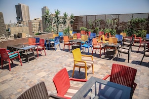 A rooftop patio with outdoor seating and city views.
