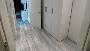 Ein Flur mit Schrank, Schreibtisch und einem Bett im Hintergrund.