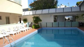 Ein Swimmingpool mit Liegestühlen und einer Leiter.
