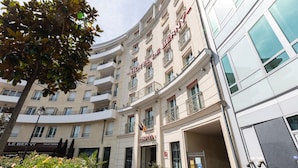A multi-story hotel with a prominent entrance, balconies, and a visible bar area. - Hôtel de Berny (Antony)