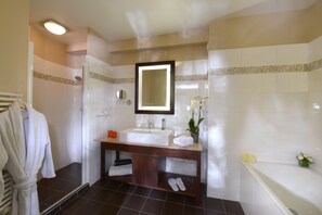 Un baño moderno con un lavamanos grande, espejo y ducha.