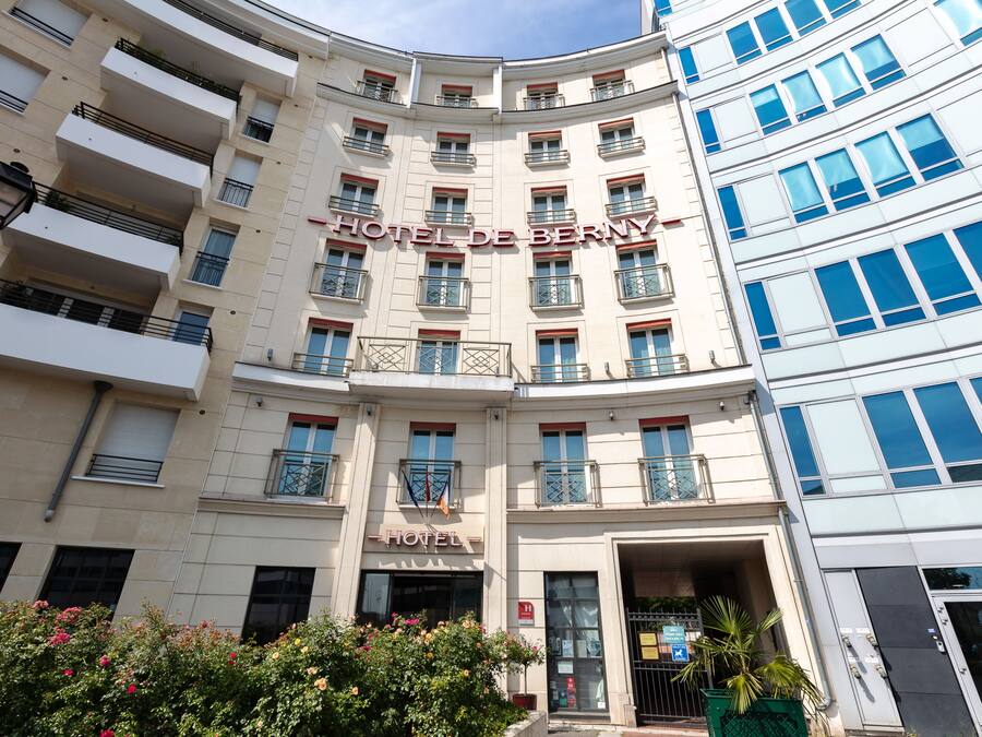 A multi-story hotel building with balconies and a sign reading "HOTEL DE BERNY".