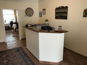 A kitchen with a central island, a clock on the wall, and a framed picture above the island. - Bremer Apartmenthotel (Bremen)