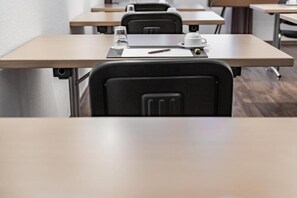 A conference room with a table, chairs, a white cup, a glass, and a pen. - Hotel Am Marschiertor (Aachen)